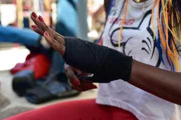 Cuban boxer putting on one of her black hand wraps during a session at the Rafael Trejo Boxing Gym, Havana, Cuba