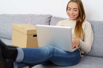 frau plant ihren umzug und sucht am laptop nach informationen