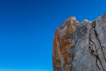 Iron tinted eroded granite rock against blue sky