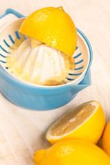 Flat lay above three lemons and plastic strainer