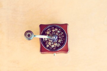 Vintage coffee grinder with coffee beans in coffee shop.
