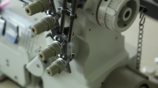 Closeup of details of professional sewing machine in factory interior. Real time full hd video footage.