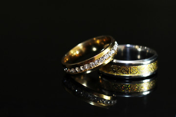 Wedding rings on a black glossy background