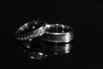 Wedding rings on a black glossy background