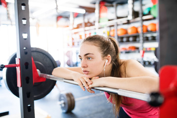 Young woman in gym, earphones in her ears,listening music