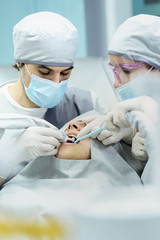 Dental surgery - Implant. Dentist surgeon with assistant