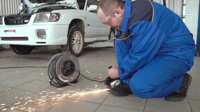car mechanic work with circular saw cutting metal with sparks in super slow motion 120 fps