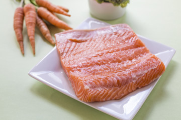 portions of fresh salmon fillet and vegetables