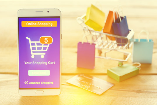 White smart device shows an online shopping screen app with five items in a basket and waiting for customer / shopper to confirm and checkout. Online shopping, online digital money payment concept.