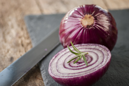 red onion cut close up on wooden board
