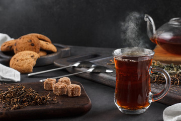 Steaming cup of tea, still life on a dark background