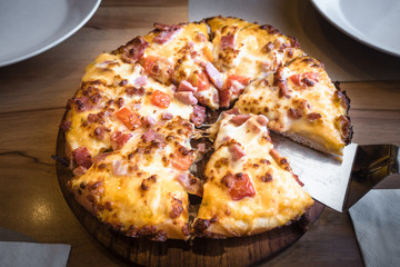 Hot Pizza slice ham and cheese with wood background.
