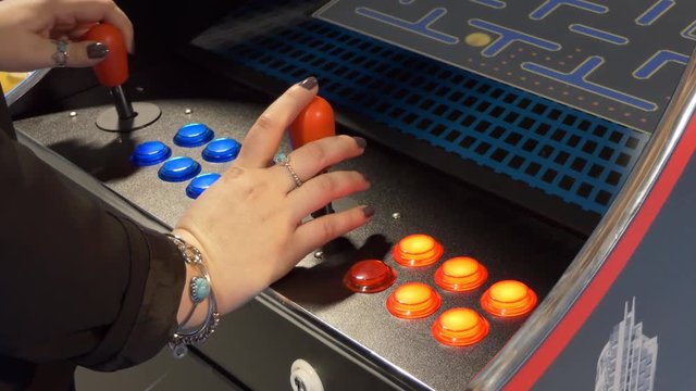 Close up of woman hands playing on game machine in the amusement arcade
