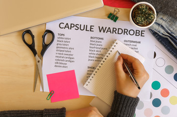 Woman creating a capsule wardrobe: fashion, minimalist and technology concept. Flat lay