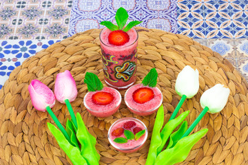 A cup of Strawberry Juice with mint leaves on an Oriental Colorful Background / Cup of Strawberry Juice on an Oriental Colorful Background with Flowers & mint leaves