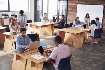 Young adult colleagues working in busy office, elevated view