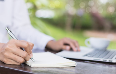 Business woman write on notebook outdoor in coffee shop.