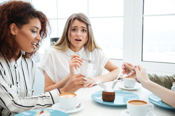 Young upset woman sitting in cafe