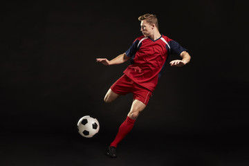 Professional Soccer Player Shooting At Goal In Studio