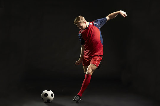 Professional Soccer Player Shooting At Goal In Studio
