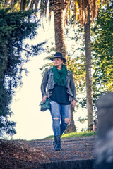 Fashionable 30-something woman walking through city park