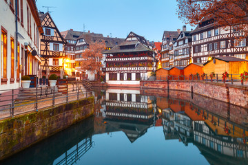 Traditional Alsatian half-timbered houses in Petite France with mirror reflections during morning blue hour, Strasbourg, Alsace, France - obrazy, fototapety, plakaty