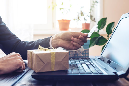 Man Working In The Office At Laptop Buying Gift Online