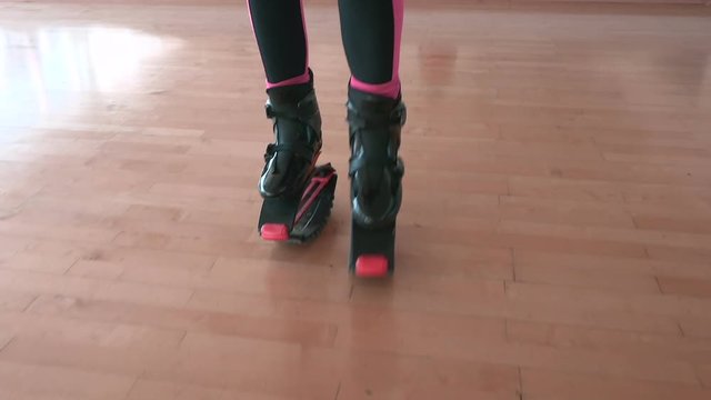 The woman in kangoo shoes walking in gym