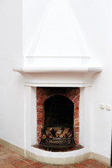 Fireplace with firewood in the furnace in the old building