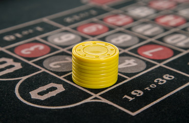gambling on a roulette table with yellow chips