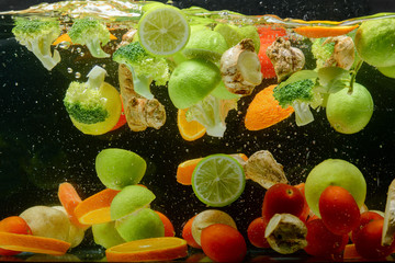 Fototapeta na wymiar Fresh Fruit and Vegetable dropping in water