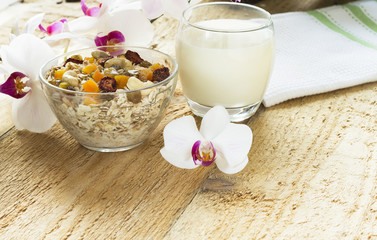 An ideal, healthy breakfast. Oatmeal on an old wooden table with flowers