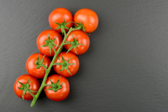 Tomaten - Rispentomaten auf einer Schieferplatte mit Textfreiraum