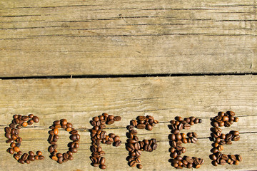 Inscription of coffee from coffee beans on wood background
