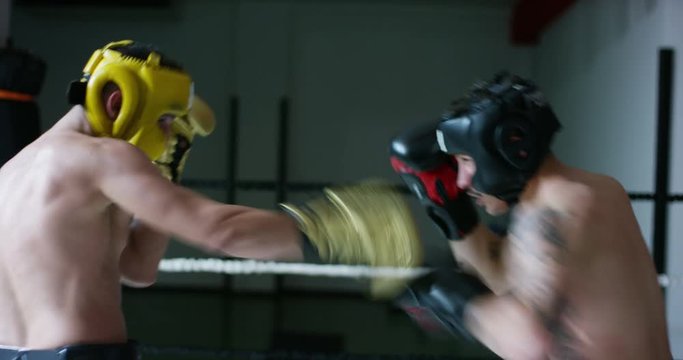 Professional sparring of two (young) partners of boxers in the ring, practice strike technique, rack, defense and endurance, in protective helmets. Concept: love sports, young boxers, love to win.