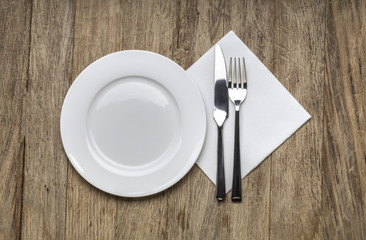 white plate, knife and fork at napkin