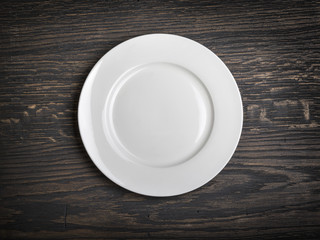 Empty white plate on wooden
