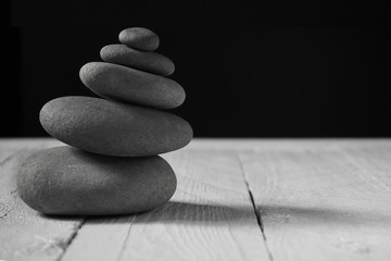 Balance stones on wooden floor and black background