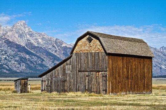 Wooden Barn and Outhouse In Front of Grand Teton Mountain Range 