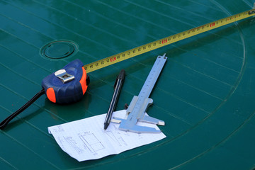 Measurement tools on table: caliper and roulette.