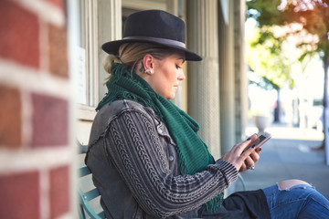Fashionable 30-something woman looking down on her mobile device