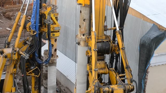 MOSCOW, RUSSIA - MARCH 11, 2017: Construction site with hydraulic machines clogging building piles in the construction of high-rise building foundation