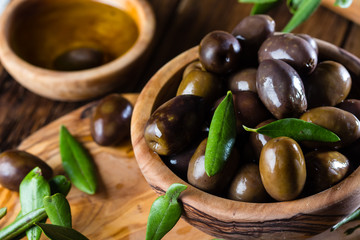Olives and olive oil in olive wooden bowls