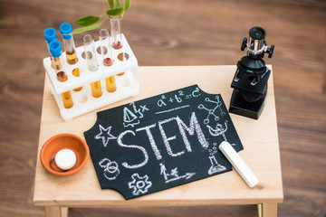 STEM education. Chalk on a blackboard. Physics. Chemistry. Biology. Mathematics. Engineering. Test tubes and microscope.