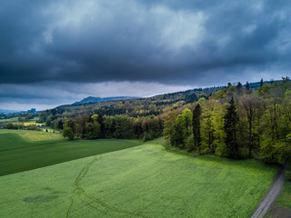 Fototapeta na wymiar Dramatic clouds on aerial view on rural landscape in Switzerland, rain coming