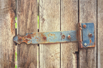 A fragment of old fence with metal items.