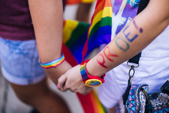 Close Up Of Couple Holding Hands During Pride Parade