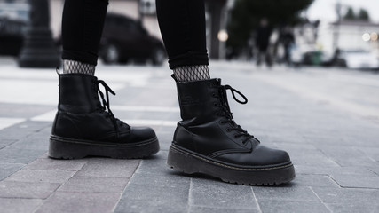 Girl fashion concept. girl wear black stylish leather boots and walk outdoors.