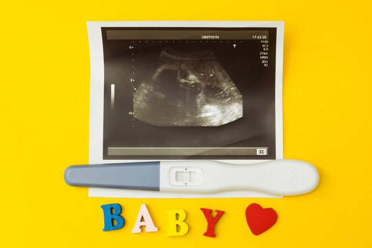 Ultrasonic image and positive pregnancy test and the word "baby".