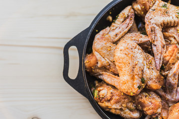 Chicken wings pickled for grilling on the right side of the frame